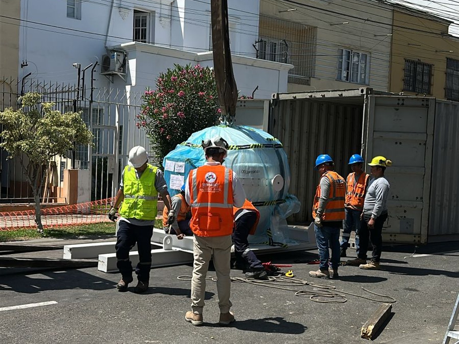 Descarga de la unidad de radiación del Gamma Knife Esprit desde el contenedor de transporte en la vía pública. El componente, protegido con embalaje especial, fue manipulado con eslingas por el equipo técnico especializado antes del izaje.