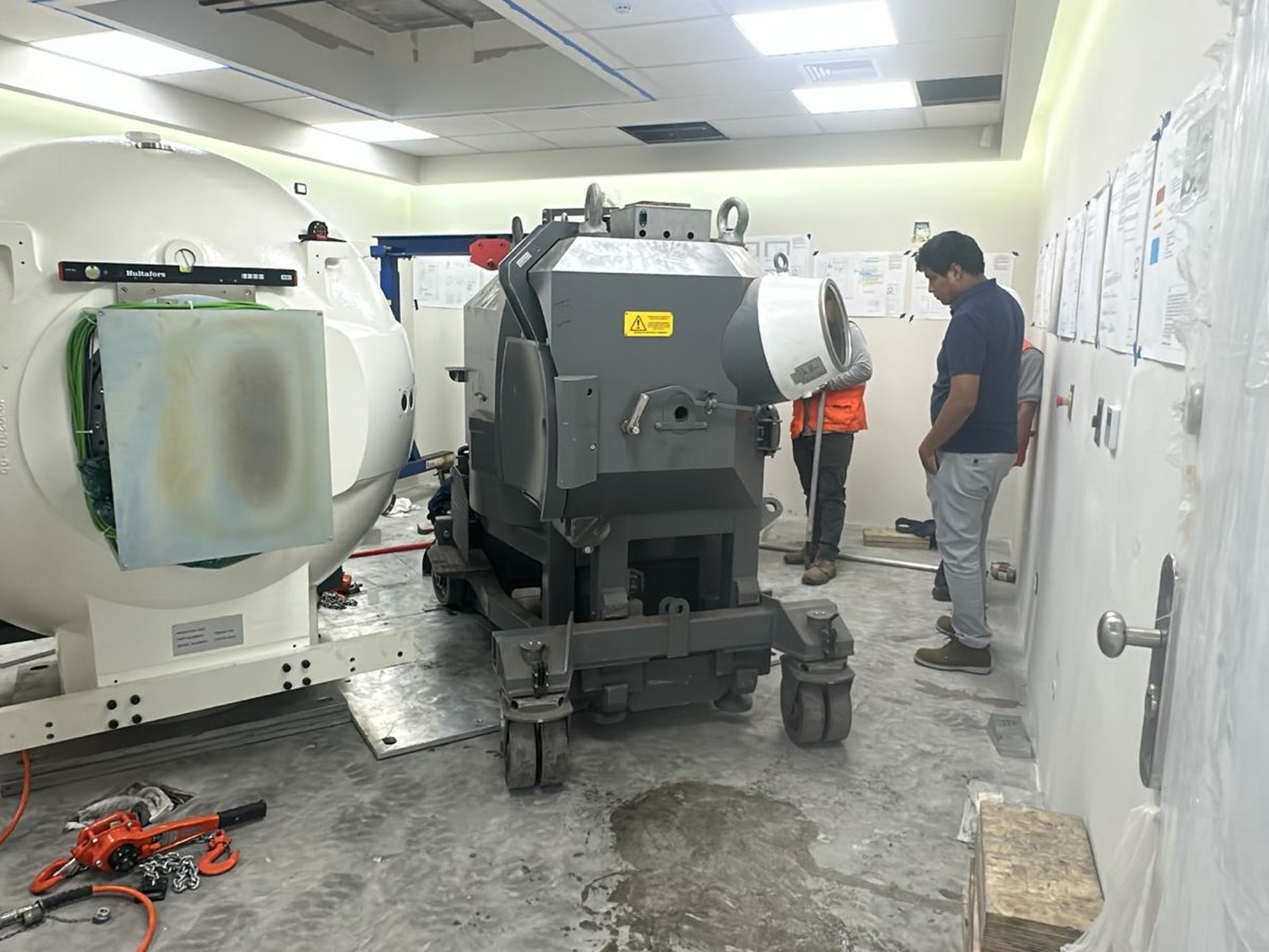 Ingreso del robot de instalación al búnker a través del corredor interior. Los técnicos del fabricante coordinan su traslado montado sobre ruedas de precisión hasta la posición exacta frente a la unidad de radiación.