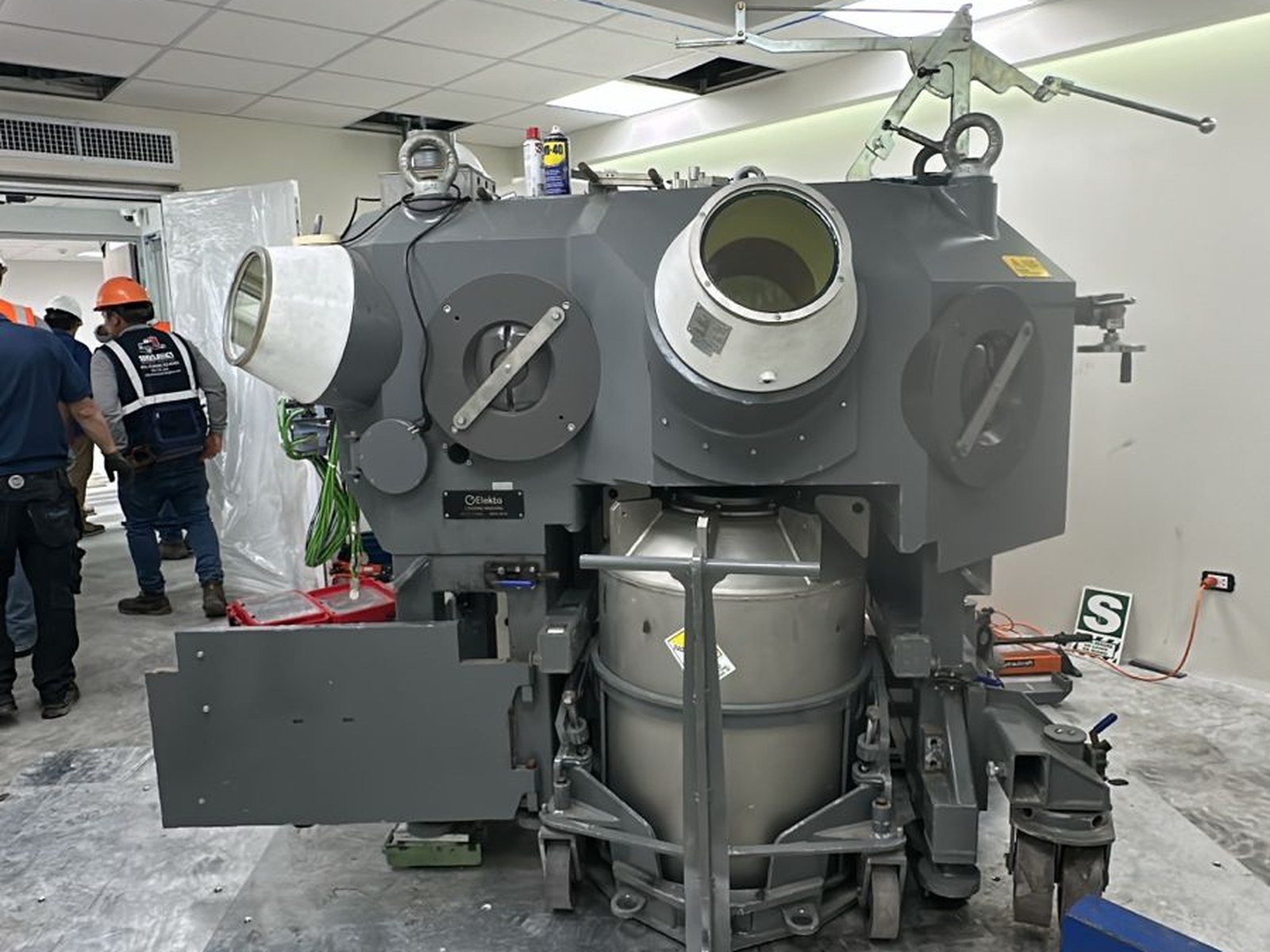 Robot de instalación (Elekta) con el contenedor de fuentes de cobalto-60 acoplado en su base, posicionado sobre la losa de 65 cm dentro del búnker y listo para la conexión con la Radiation Unit. Este conjunto —contenedor de fuentes, robot de carga y unidad de radiación— forma el sistema completo de instalación de semillas radiactivas del Gamma Knife Esprit.